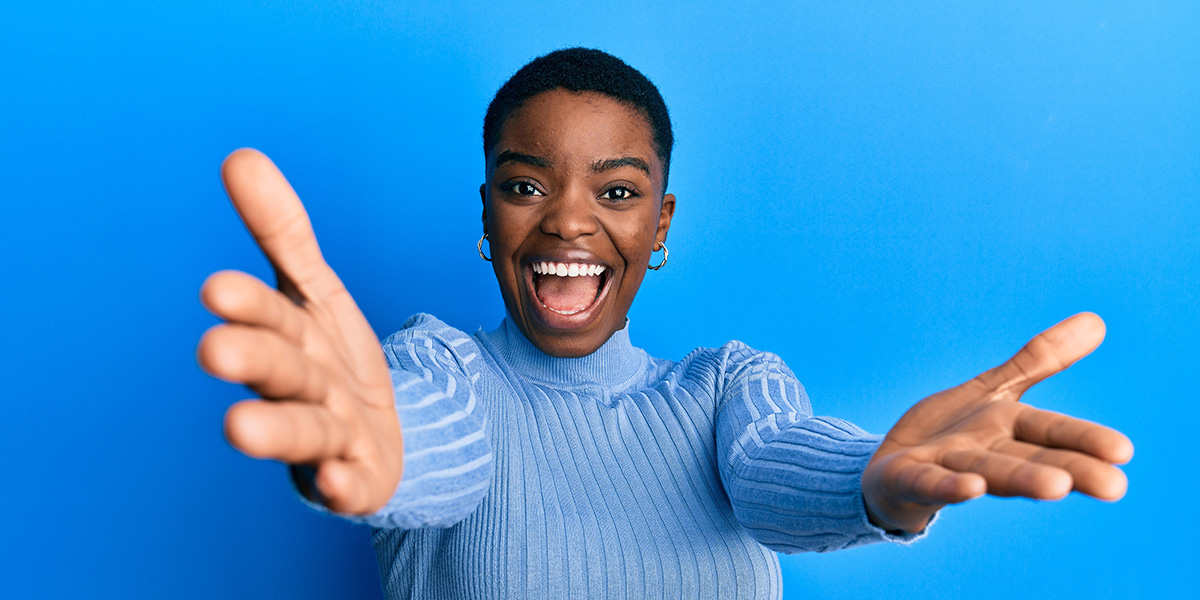 Young african american woman wearing casual clothes looking at the camera smiling with open arms for hug. cheerful expression embracing happiness.